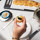 Hand picking up a bilni with caviar on top